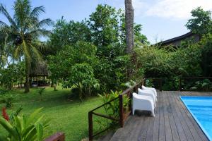 a deck with white chairs next to a swimming pool at Oasis Bluff Beach in Bocas Town