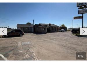 a car parked in a parking lot next to a building at El Muir Motel in Fresno