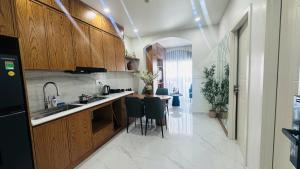 a kitchen with wooden cabinets and a table and chairs at Sunrise Home in Xóm Niêm