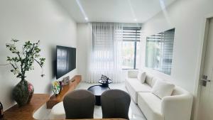 a living room with a white couch and a table at Sunrise Home in Xóm Niêm