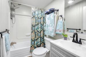 a bathroom with a toilet and a shower curtain at Wild Rhodes in Wimberley