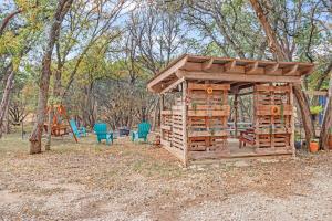 a wooden play structure with chairs and a playground at Wild Rhodes in Wimberley