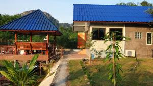 a house with a blue roof with a porch at Min Land Resort in Ban Lan Nok