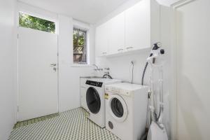a kitchen with a washing machine and a washer at Collaroy 3Br Beach Home with Large Pool Ground Floor in Collaroy