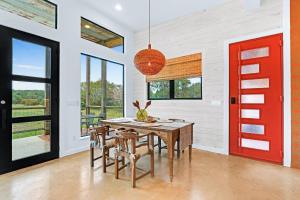 a dining room with a red door and a table and chairs at Wild Candy-Plum Wild in Wimberley