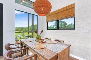 a dining room with a table and chairs and windows at Wild Candy-Plum Wild in Wimberley +37 photos