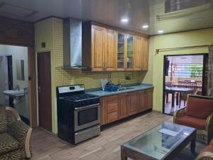 a kitchen with wooden cabinets and a stove top oven at Hostel Archimedes in Paramaribo +54 photos
