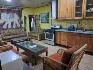 a kitchen with a living room with a table and chairs at Hostel Archimedes in Paramaribo