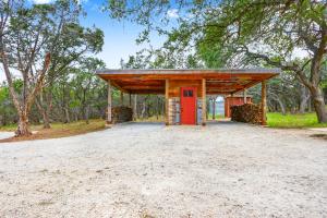 a building with a red door in a field at Wild Candy-Fruit Tramp in Wimberley
