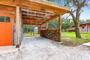 a barn with a pile of fire wood under it at Wild Candy-Fruit Tramp in Wimberley