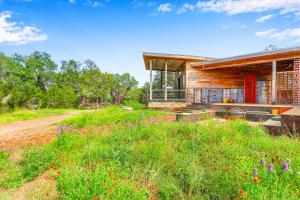 a house on a hill with a field of flowers at Wild Candy-Fruit Tramp in Wimberley
