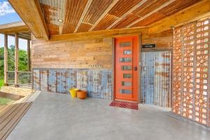 an entrance to a wooden building with an orange door at Wild Candy-Fruit Tramp in Wimberley