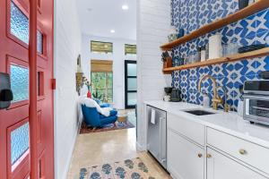 a kitchen with blue and white walls and a red door at Wild Candy-Fruit Tramp in Wimberley +28 photos