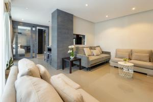 a living room with a couch and a table at 2BR Family Condo with a Pool View - CTG P205 in Kamala Beach