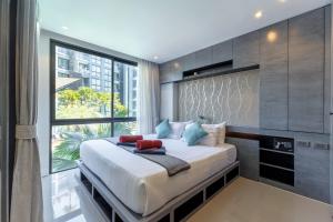 a bedroom with a large bed with a large window at 2BR Family Condo with a Pool View - CTG P205 in Kamala Beach +13 photos
