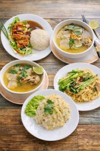a group of plates of food on a wooden table at Hi Homestay in Battambang