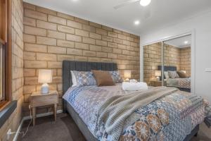 a bedroom with a bed and a brick wall at Route 86 Bright in Bright +20 photos