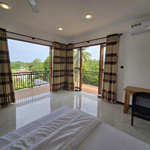 a bedroom with a bed and a balcony at Waypoint Resort and Apartments in Hikkaduwa +177 photos