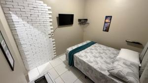 a bedroom with a bed and a tv on the wall at Suíte aconchegante 2 in Nova Mutum