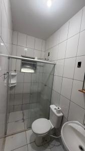 a white bathroom with a toilet and a sink at Suíte aconchegante 2 in Nova Mutum