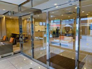 a lobby with glass doors in a building at Smile Hotel Sugamo in Tokyo