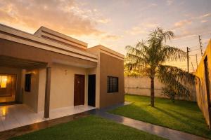 a house with a palm tree in the yard at Suíte aconchegante 2 in Nova Mutum