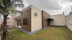 a building with a palm tree in front of it at Suíte aconchegante 2 in Nova Mutum +7 photos