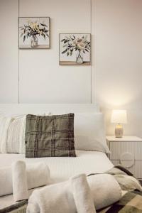 a bedroom with a white bed with two pictures on the wall at Two Bedroom Unit in Central Adelaide in Adelaide +16 photos