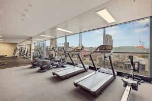 a gym with a row of treadmills and a large window at Two Bedroom Unit in Central Adelaide in Adelaide