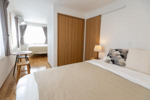 a bedroom with a large bed and a stool in it at Sa one ko Matsumoto Entire house Free parking 2cars in Matsumoto