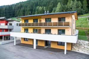 een appartementencomplex met geel en wit bij Bergblick-Planai - 5 Schlafzimmer plus eigene Sauna in Schladming