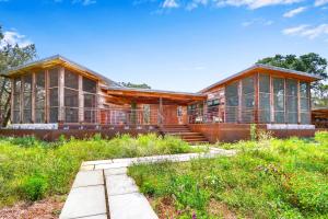 a large house with glass windows in a field at Wild Candy-Blue Yodel in Wimberley