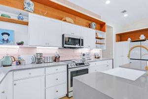 a white kitchen with white cabinets and a microwave at Wild Candy-Blue Yodel in Wimberley