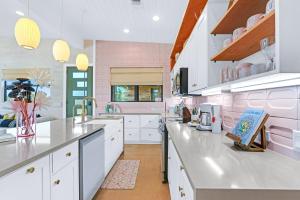 a kitchen with white counters and pink walls at Wild Candy-Blue Yodel in Wimberley +34 photos