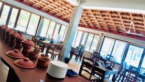 a dining room with tables and chairs and windows at Saachi Lagoon Resort in Kalpitiya