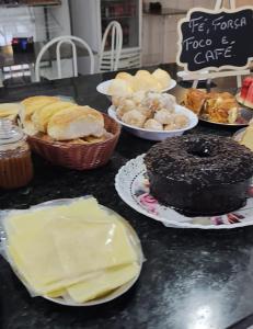 a table topped with plates of pastries and cakes at Hotel Entre Lagos in São José do Cerrito