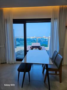a dining room with a table and chairs and a large window at Nolgureum private pool villa in Jeju