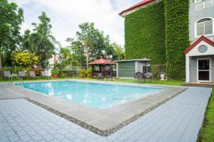 a swimming pool in front of a house at Microtel by Wyndham Batangas in Santo Tomas