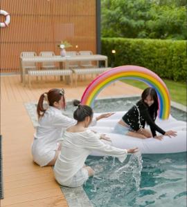 a group of girls playing in a pool with a rainbow at Villa Nordic Private Pool Pakchong in Ban Thung Sawang +10 photos