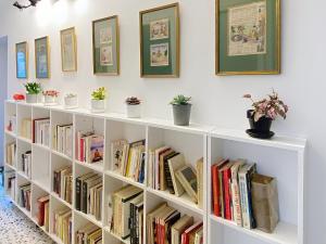 a white book shelf filled with books and potted plants at Sejour paisible au Thor in Le Thor
