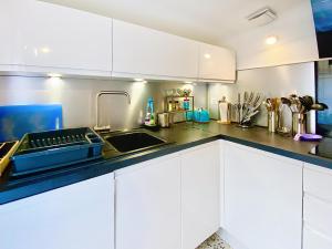 a kitchen with white cabinets and a sink at Sejour paisible au Thor in Le Thor