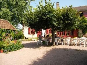 grupa ludzi siedzących przy stole pod drzewem w obiekcie Chambre familiale proche du PAL -Cardamome- w mieście Saligny-sur-Roudon +19 zdjęć