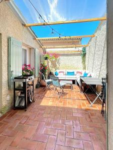a patio with tables and chairs on a brick patio at Sejour paisible au Thor in Le Thor