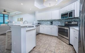 a white kitchen with white cabinets and appliances at Phoenix West 603 in Orange Beach