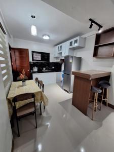 a kitchen with a table and chairs and a kitchen with a counter at Casa Alegre Lipa in Lipa