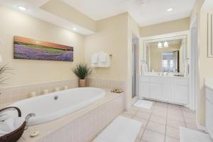 a white bathroom with a tub and a shower at Whispering Ridge Ranch in Wimberley