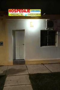 a white building with a white door and a sign at Hospedaje "Crisbel" en Las Catitas in Las Catitas