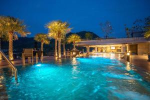 a swimming pool at night with palm trees at 2BR Family Condo with a Pool View - CTG P205 in Kamala Beach