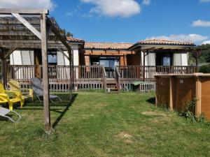 a house with a deck and a yard with chairs at Les bichous in Saint-Thomas