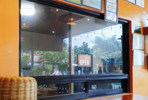 a store window with a sign that says open at RedDoorz at Balai Malinawon Siargao in General Luna